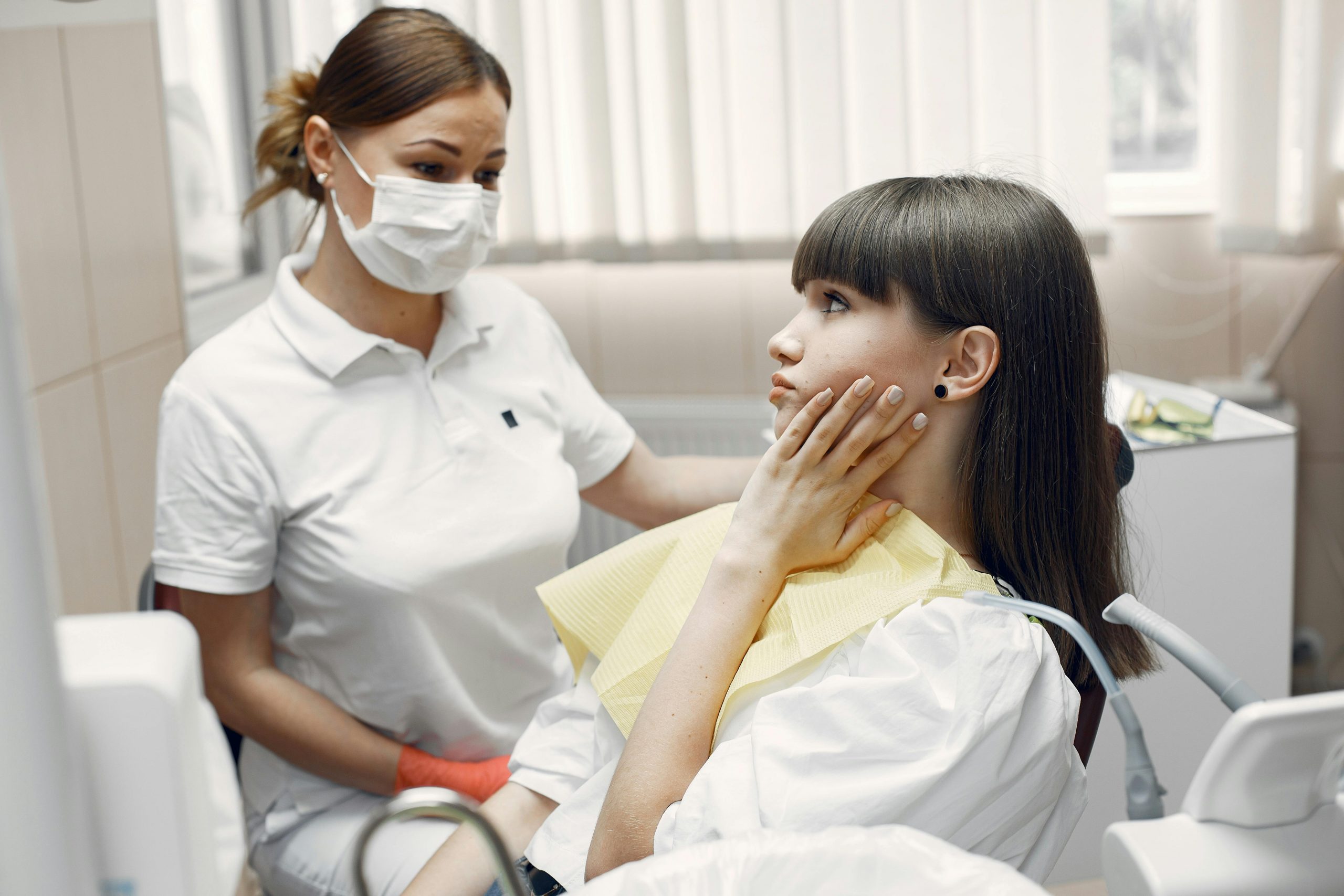 female patient speaking with her dentist while touching her jaw